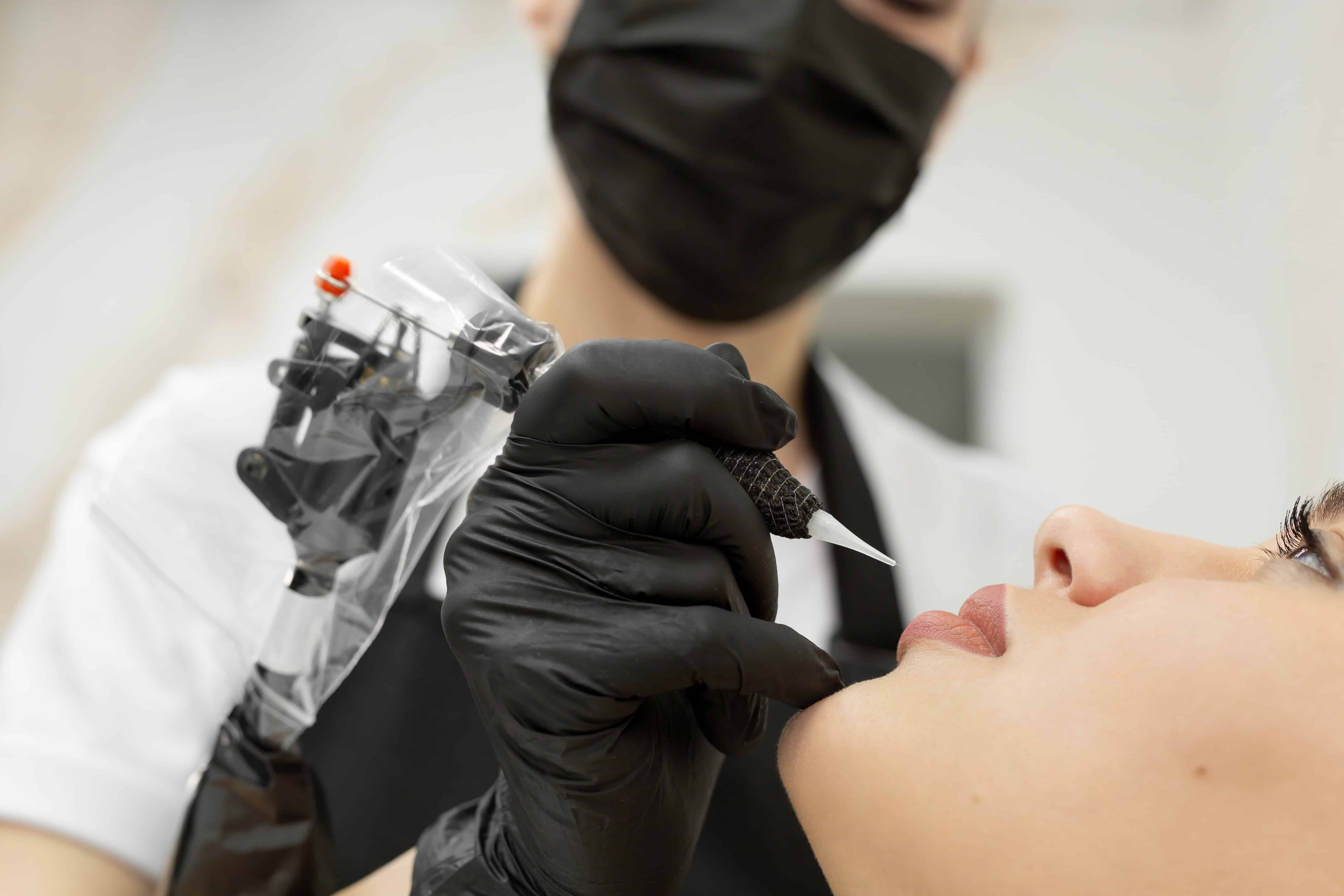 Cosmetologist applies permanent makeup to the lips in the salon