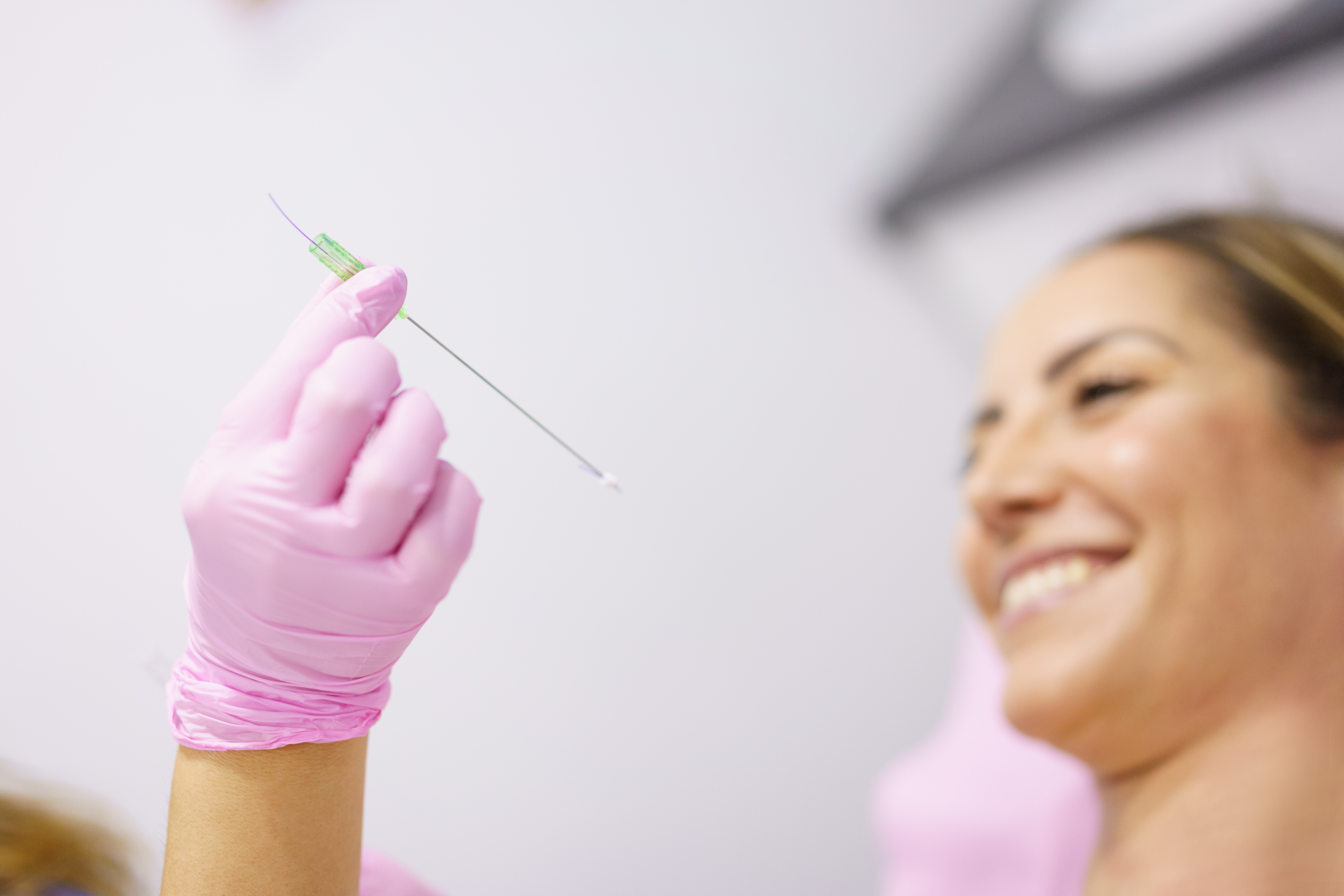 Doctor showing a PDO treatment suture thread to her patient.