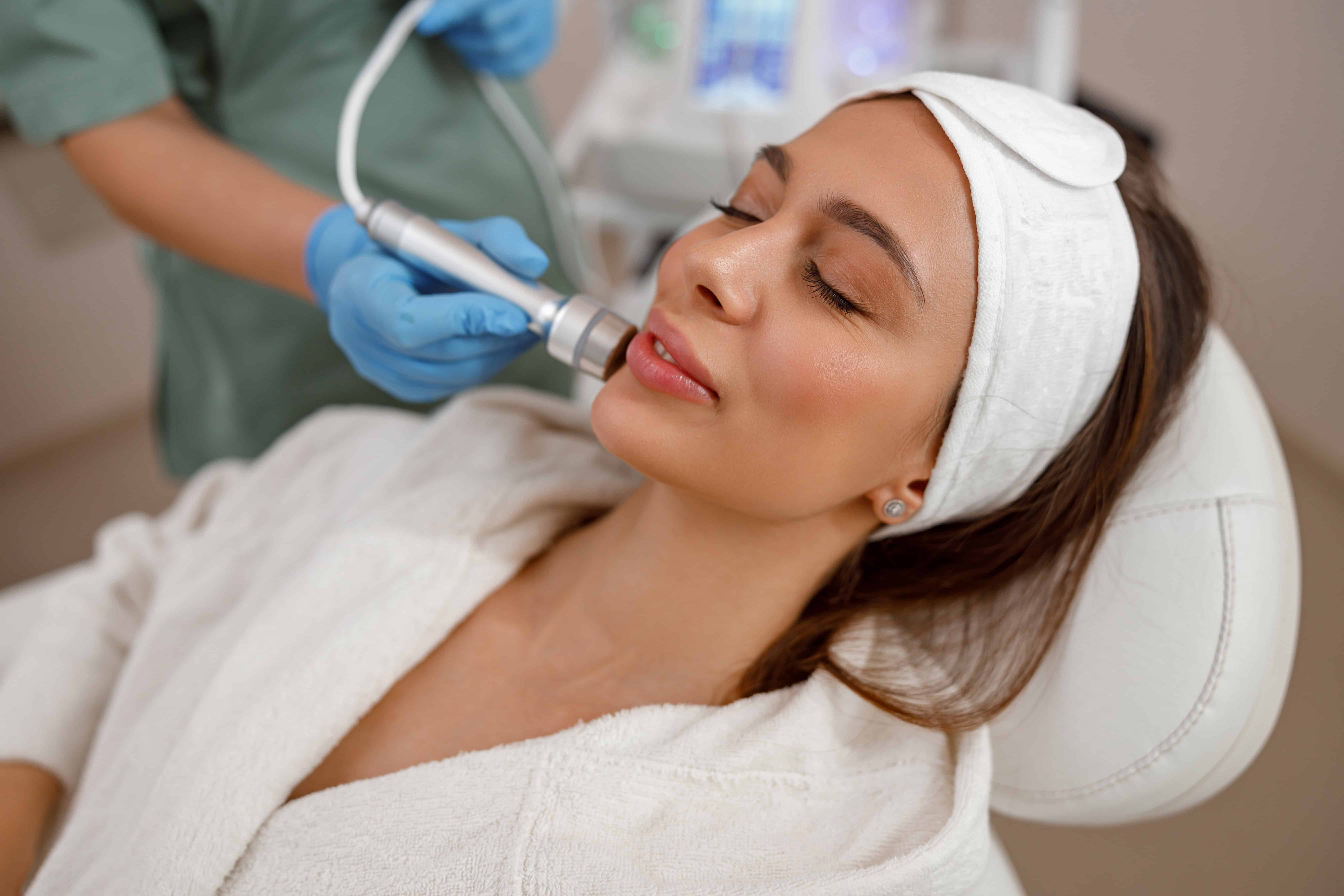 Female client getting aesthetic facial skin treatment in beauty salon