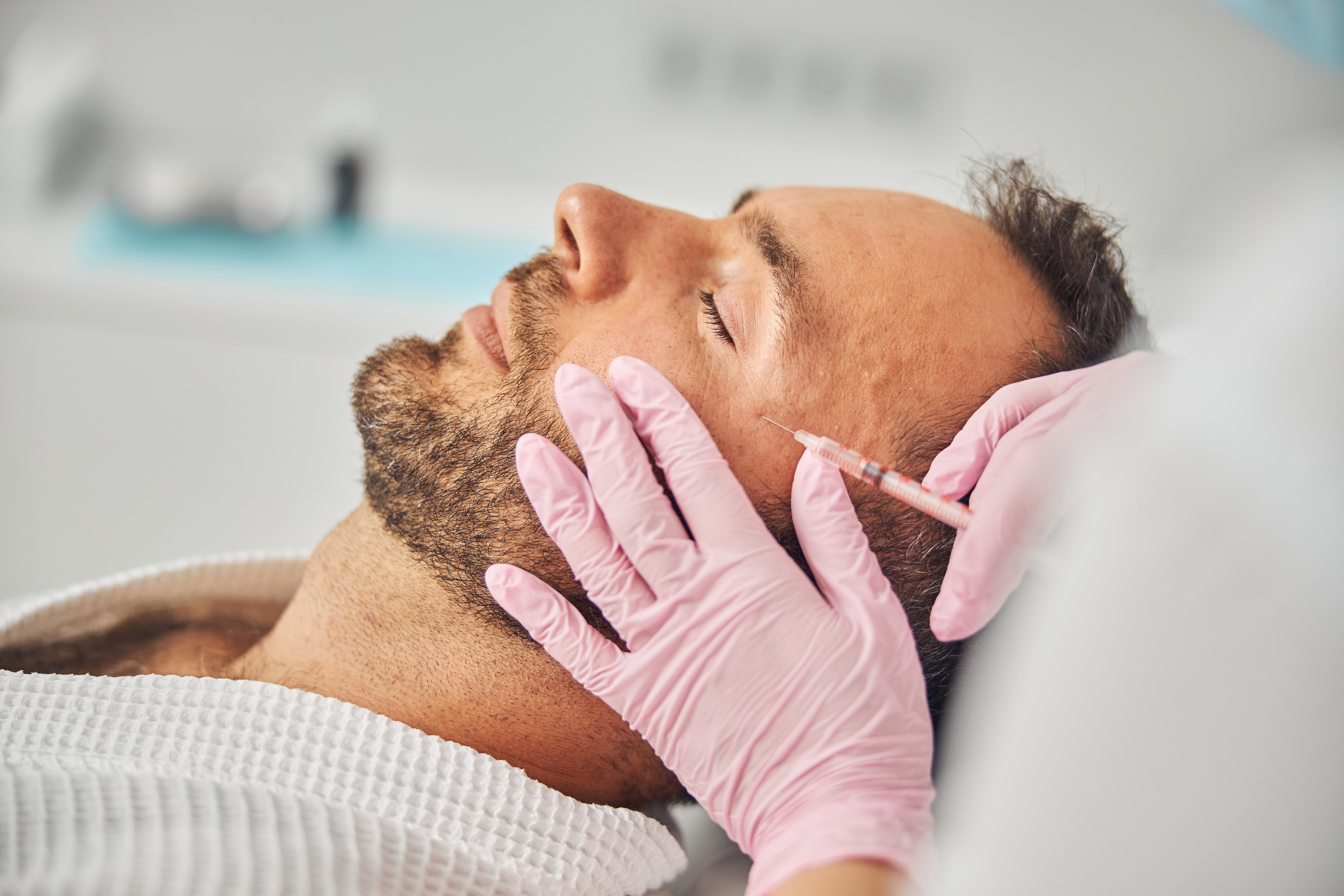 Handsome young man receiving cosmetic facial injections