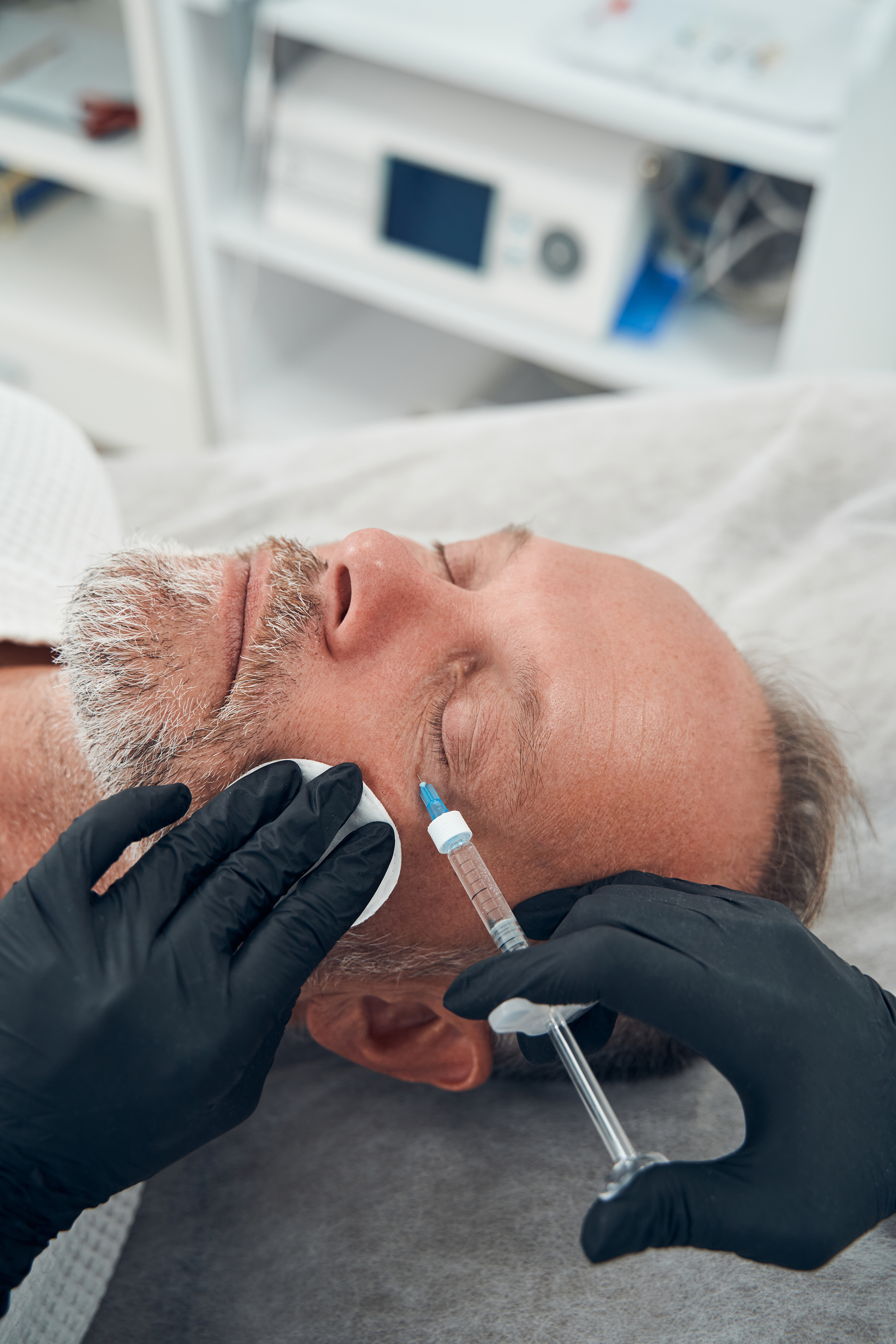 Man having anti-aging injection procedure in cosmetology clinic