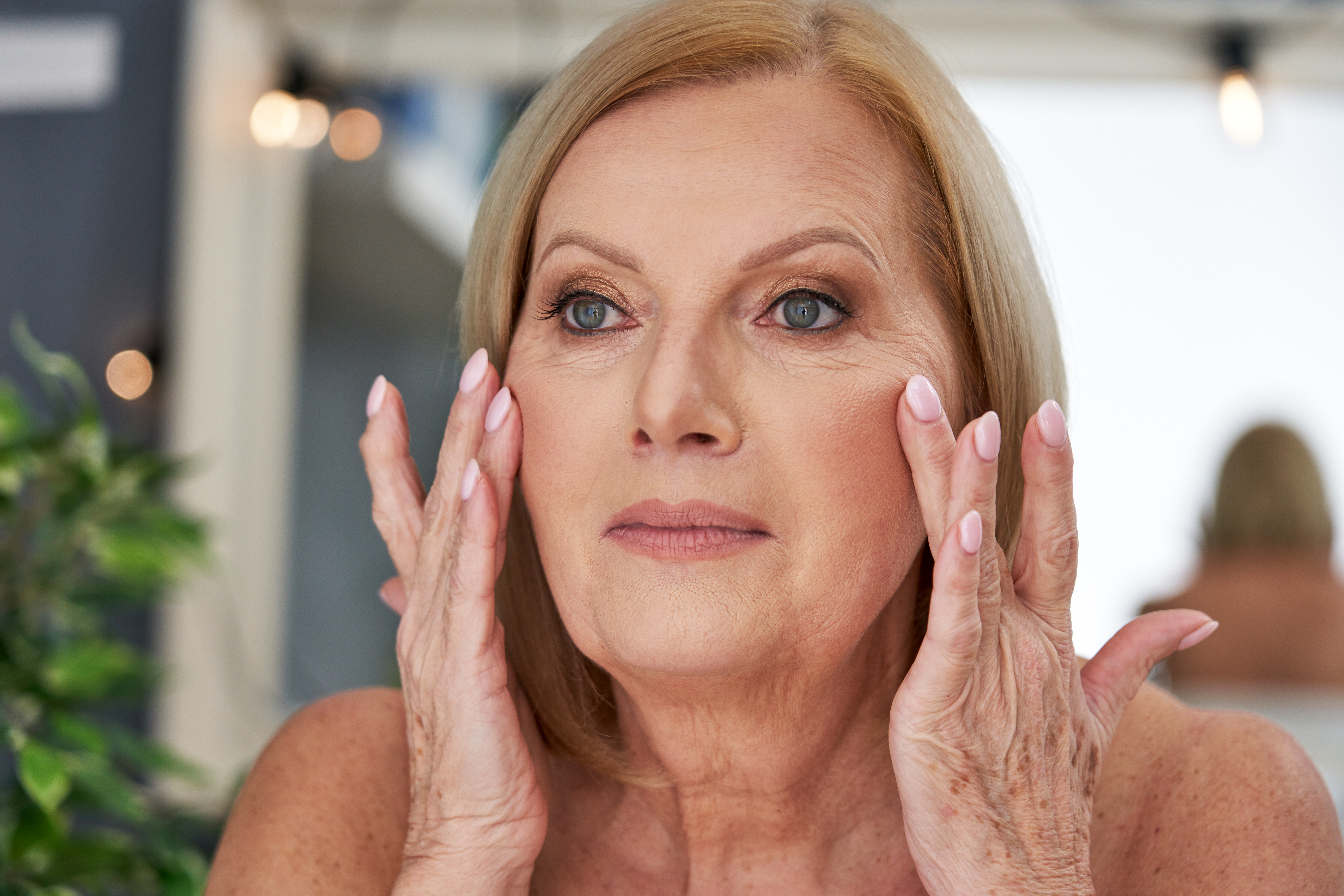 Senior woman using anti wrinkle cream in the bathroom