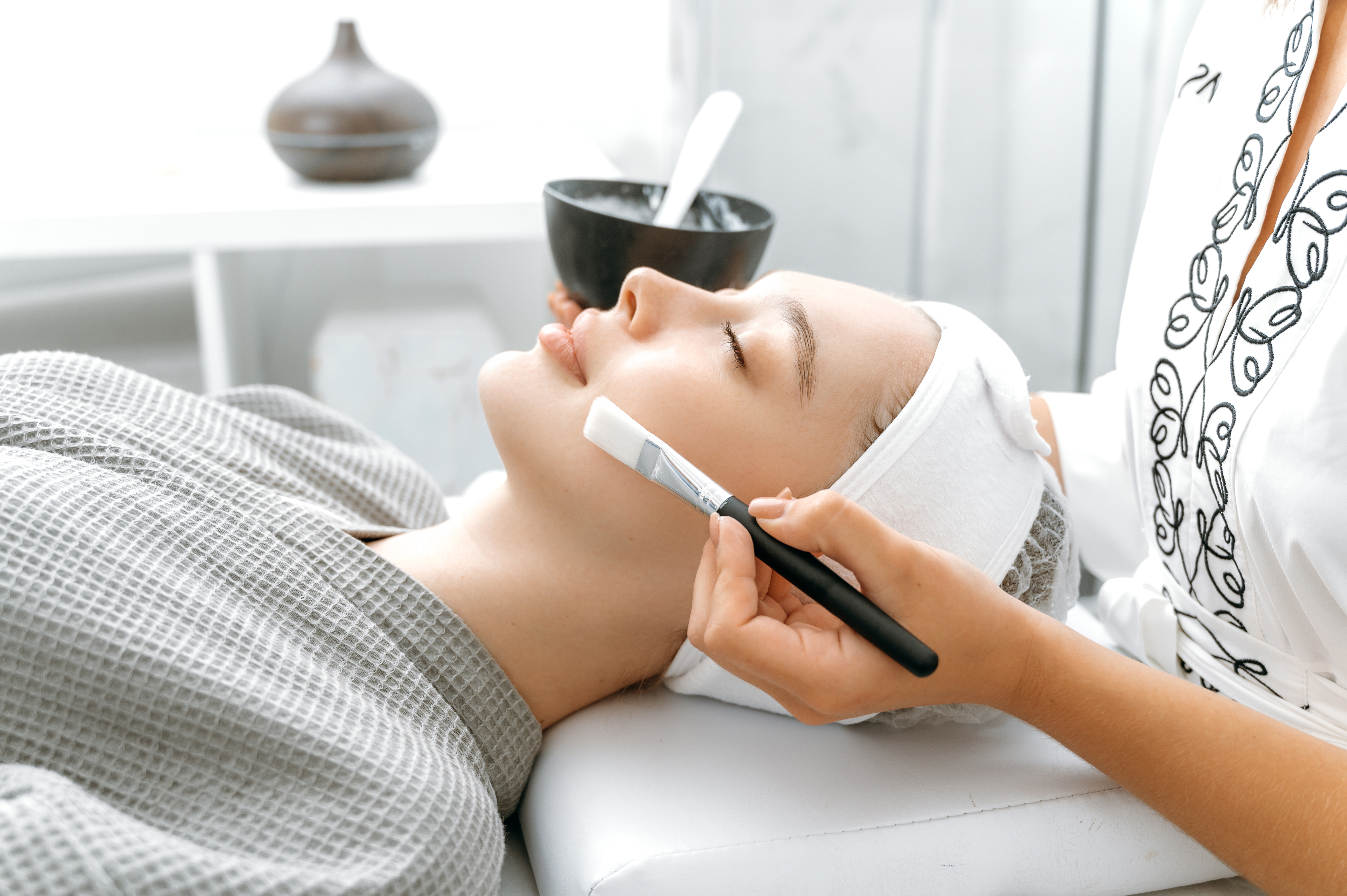 Side view of a caucasian relaxed woman lying in a salon with her eyes closed during a beauty