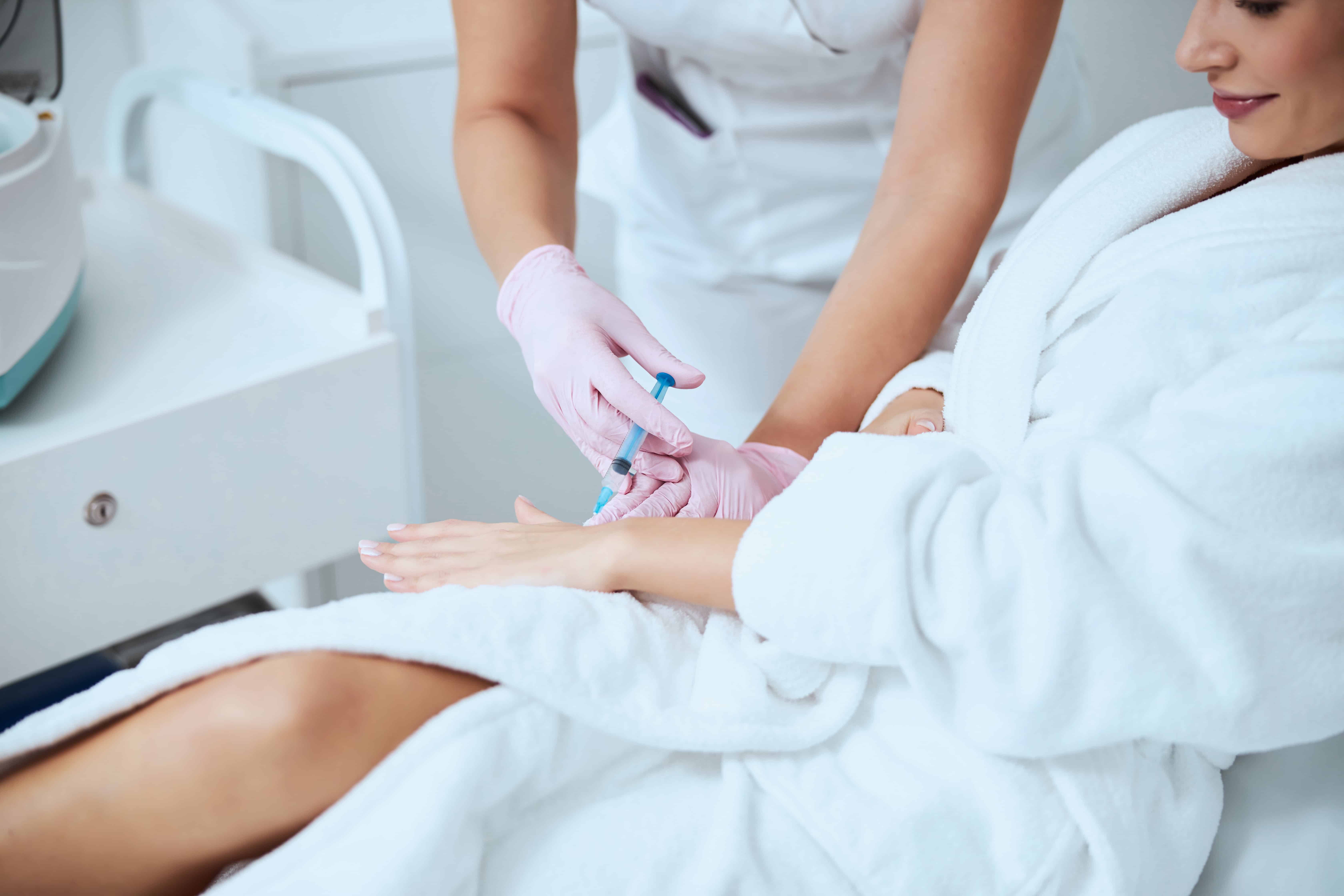 Woman client undergoing the hand rejuvenation procedure