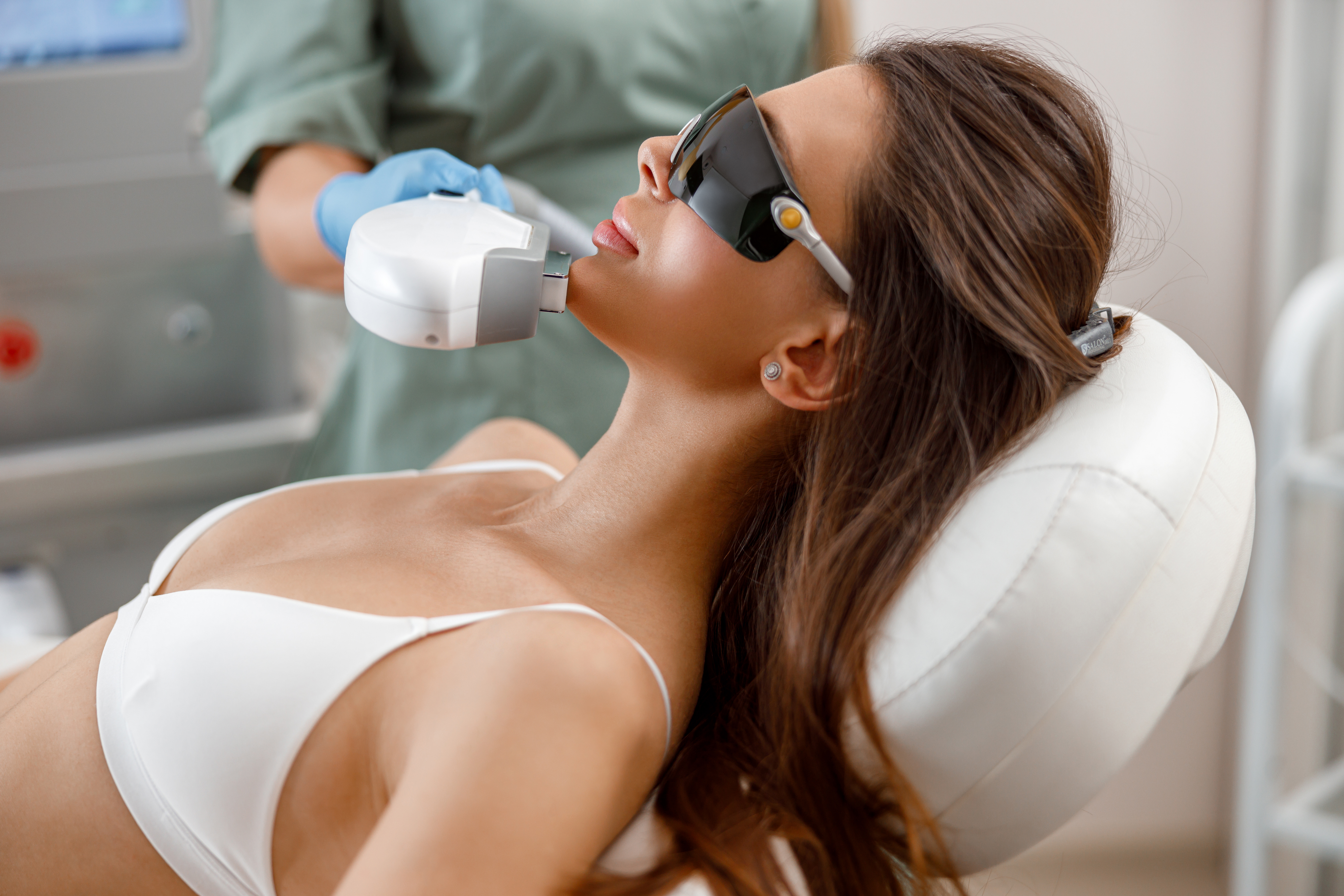 Young woman getting aesthetic face treatment in beauty salon