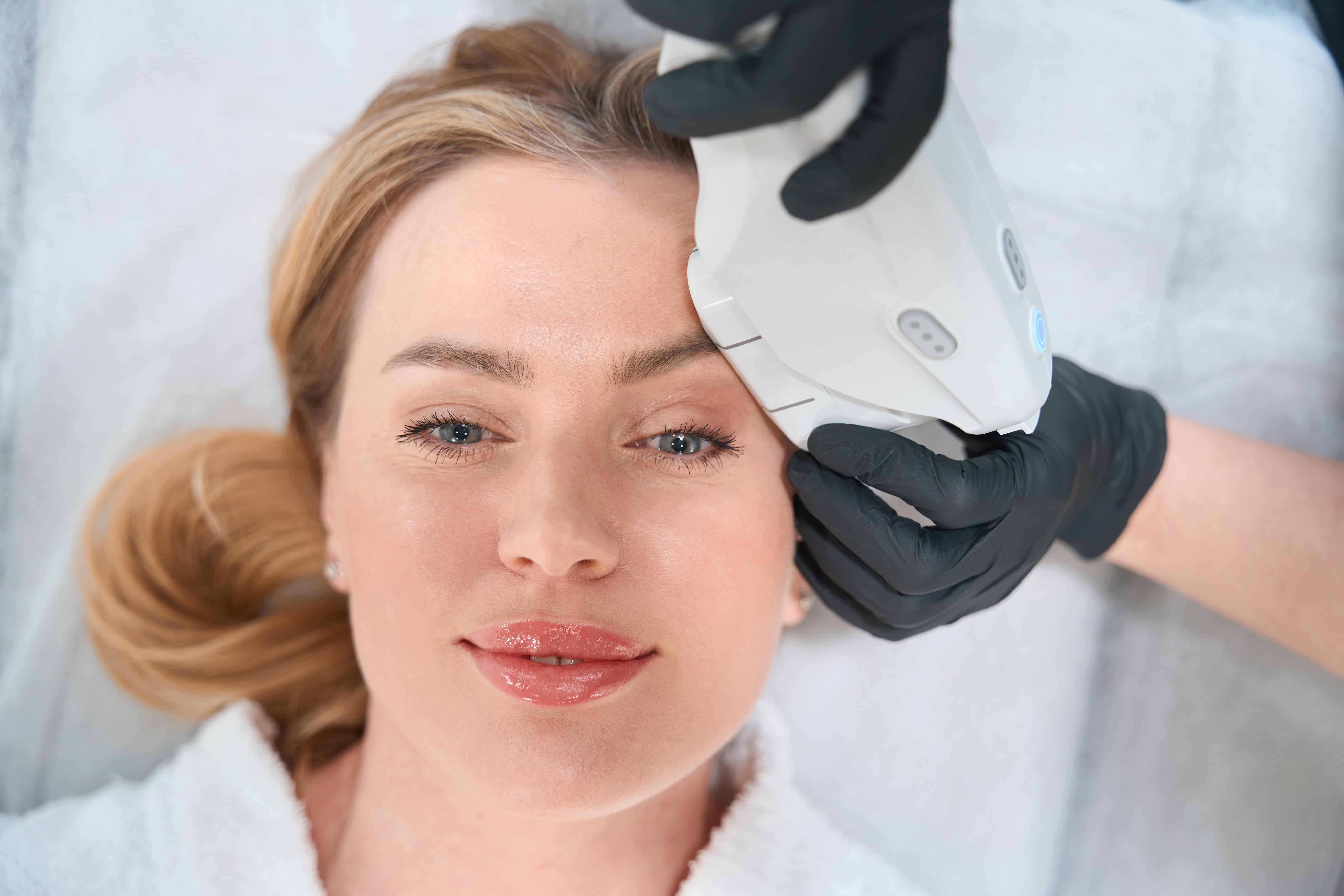 Young woman undergoes a hardware facial skin tightening procedure