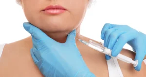 Close-up of a medical professional wearing blue gloves injecting Kybella into the area under a patient's chin to reduce double chin fat in Scottsdale, AZ