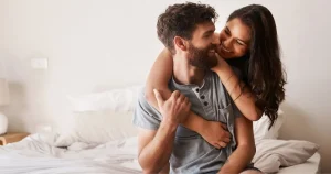 Happy couple embracing in bed, representing Men’s Sexual Health in Scottsdale, AZ