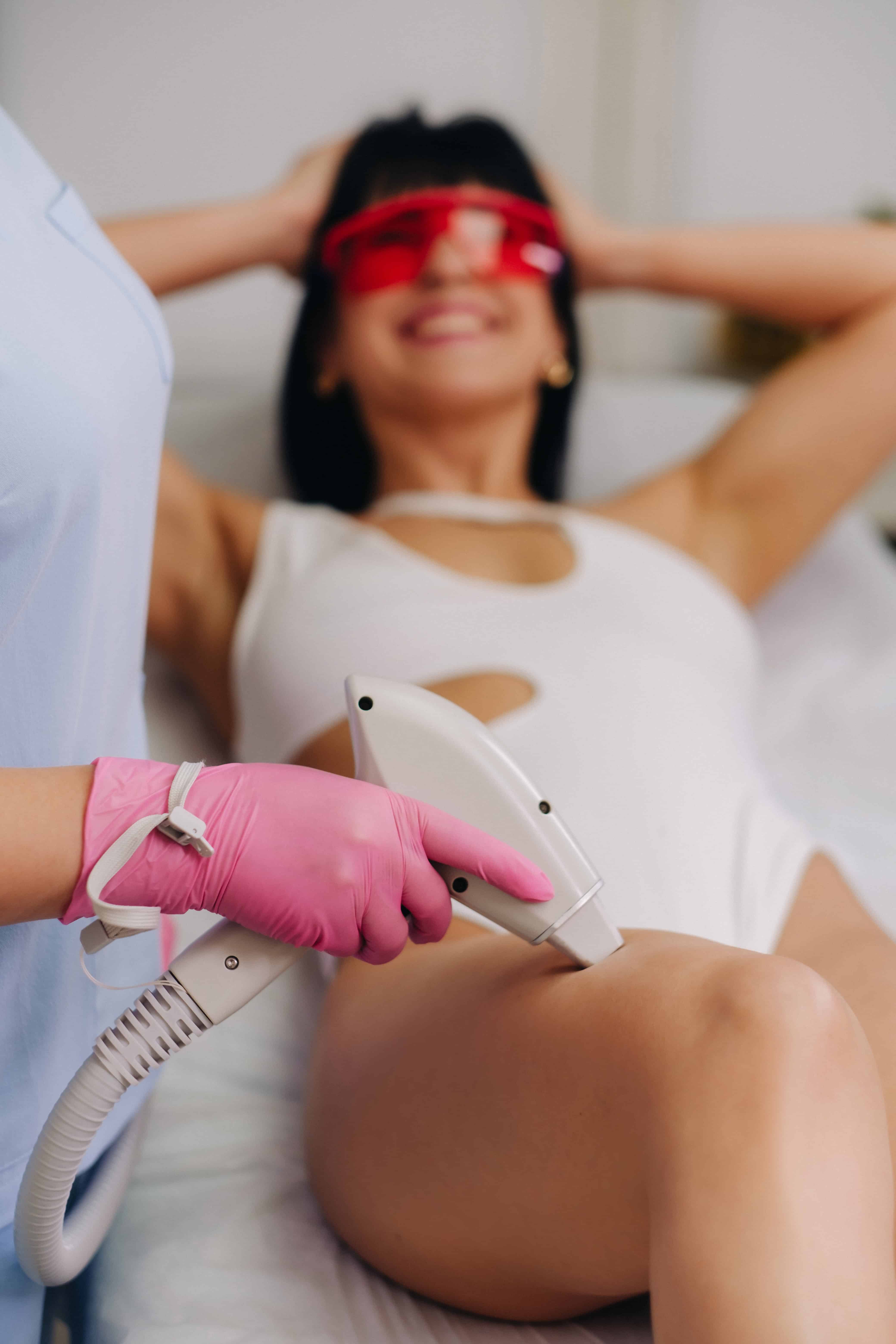 A cosmetologist performs a laser hair removal procedure in the office